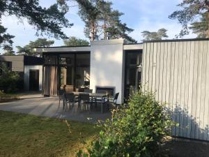 a house with a table and chairs on a patio at Jeneverbes24 in Otterlo