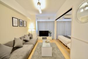 a living room with a couch and a tv at Allstay CHIBANA in Okinawa City