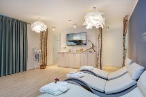 a living room with two white chairs and a couch at Apartmenthaus Am Park in Prerow