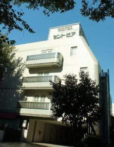 um edifício branco com um sinal na lateral em Hotel Sentpia em Higashi-murayama