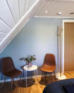 2 sillas y una mesa en una habitación con una pared azul en Lindens Bed&Breakfast, en Mellerud