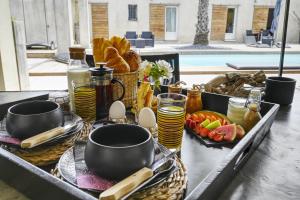 a breakfast table with food and eggs and drinks at Mas Sainte Marie in Aigues-Mortes