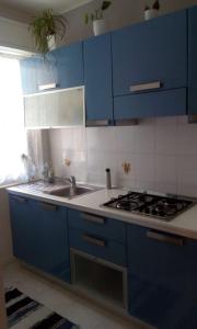 a blue kitchen with a sink and a stove at Appartamento IL PORTO in Martinsicuro