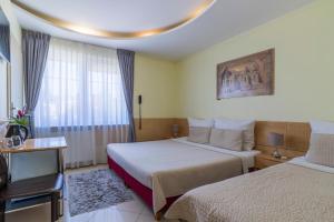 グダニスクにあるVilla Aida pokoje gościnneのベッド2台と窓が備わるホテルルームです。