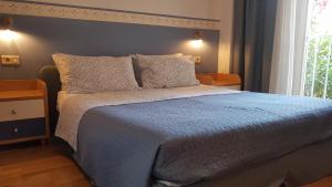 a bedroom with a bed with a blue comforter and a window at Marion apartment in Portorož
