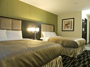 a hotel room with two beds and two lamps at Western Star Inn & Suites Esterhazy in Esterhazy