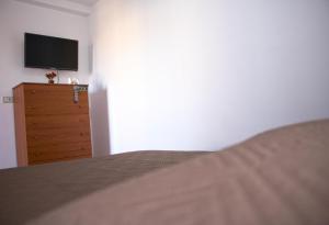 a bedroom with a bed and a dresser with a television at UMBERTO I APARTMENTs in Bagheria