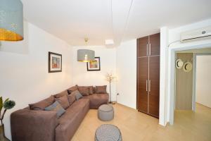 uma sala de estar com um sofá castanho num quarto em Apartments Kriva Ulica em Kotor