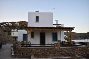 a small white house with a porch on a hill at Monolithos Villas in Kipri