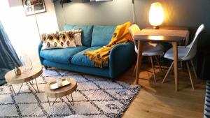 a living room with a blue couch and a table at Fiquet de Normanville pour votre bien être en plein coeur historique in Rouen