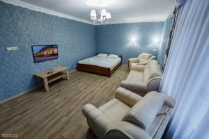 a room with a bedroom with a bed and couches at Гостинний Двір in Bar