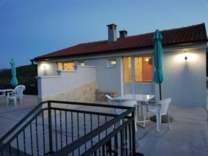 a house with a patio with a table and an umbrella at Apartmani Goga in Skradin