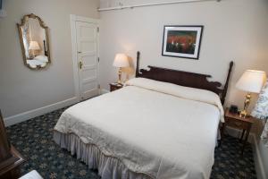 a bedroom with a bed and two lamps and a mirror at Middlebury Inn in Middlebury