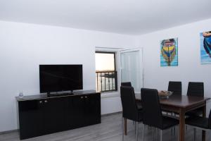 une salle à manger avec une table et une télévision dans l'établissement Bounty Apartments, à Šibenik
