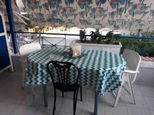 a table with a green and white checkered table cloth at karavagelis rooms in Rovies