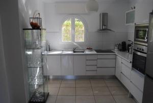 a white kitchen with a sink and a window at Villa Bozena in Denia