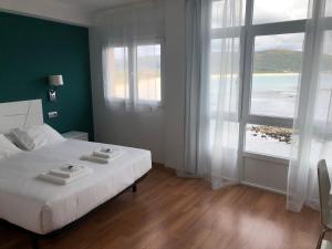 a hotel room with a bed and a window at Hotel Mar de Fisterra in Finisterre