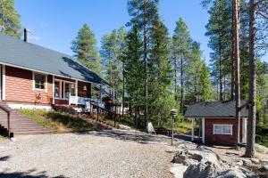 a cabin in the woods with a gravel driveway at Villa Lapintiira in Rovaniemi
