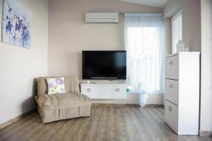 a living room with a tv and a chair at Lake House Sand in Ohrid