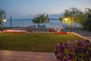 einen Garten mit Stühlen, einem Tisch und Blumen in der Unterkunft Lake House Sand in Ohrid