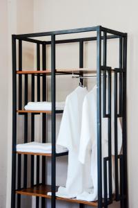 a black iron shelf with white shirts on it at Bellis in Tbilisi City