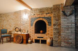 a brick fireplace with a table and a chair at Bellis in Tbilisi City