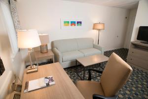 a hotel room with a couch and a table and a chair at Middlebury Inn in Middlebury