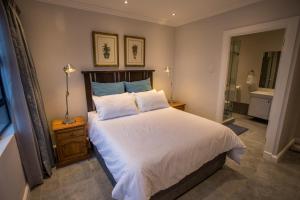 a bedroom with a large bed and a bathroom at Stay at The Point - Penthouse Plush Perfection in Durban