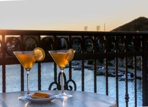 deux verres à martini assis sur une table sur un balcon dans l'établissement Bounty Apartments, à Šibenik