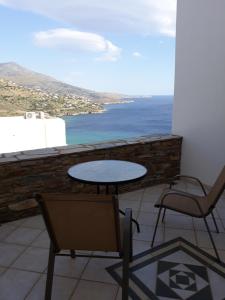 a table and chairs on a balcony with a view of the ocean at Monolithos Villas in Kipri