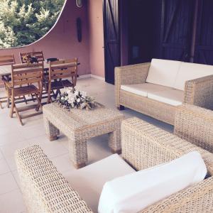 a patio with wicker furniture and a table and chairs at Chia - Casa Margherita in Chia