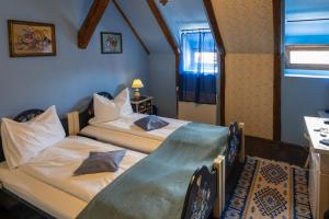 a bedroom with two beds and a table and a window at Casa Saseasca in Sighişoara