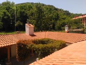 エスカライにあるAPARTAMENTOS LA CASONA DE EZCARAY CON TERRAZAS y PATIOS INDIVIDUALESの茂みと木々の家屋