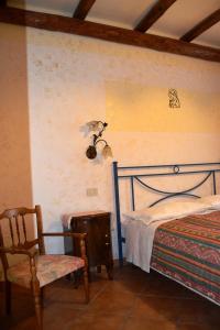 a bedroom with a bed and a chair and a lamp at Aritzo appartamento romantico in Aritzo