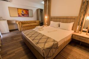 ein Schlafzimmer mit einem großen Bett und einer Couch in der Unterkunft ViiLaLac in Venus