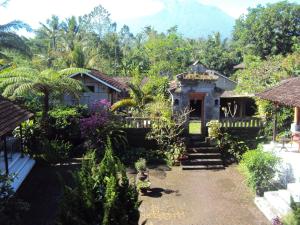 a house in the middle of a garden at Puri Agung Inn in Sidemen