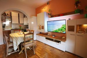 a kitchen with a table and a large screen television at Apartman Luna in Dugi Rat +26 photos