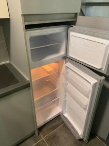 an empty refrigerator with its door open in a kitchen at Castella Apartments in Vourvourou