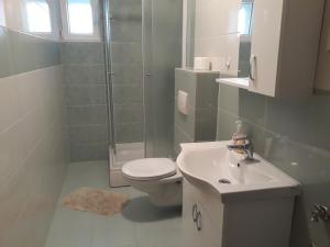 a bathroom with a toilet and a sink and a shower at Apartments Juliet in Orebić