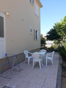 a patio with a table and chairs next to a building at Apartments Juliet in Orebić