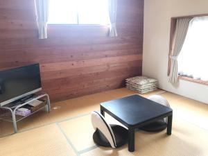 een woonkamer met een tafel en stoelen en een televisie bij Morino Garden Mashiko in Mashiko
