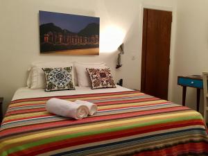 1 dormitorio con 1 cama con una manta y almohadas coloridas en Studio2 Rio Beira Mar en Río de Janeiro