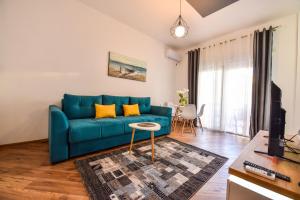 ウルツィニにあるDragovoja Lux Apartments & Roomsの青いソファとテーブルのあるリビングルーム