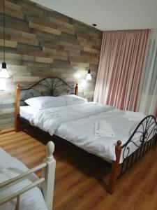 a bedroom with two beds and a wooden wall at Sakhli Laghamshi in Mestia