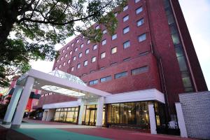 a large red brick building with a walkway in front of it at Kurayoshi City Hotel in Kurayoshi