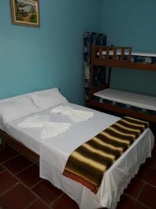 ein Schlafzimmer mit einem Bett mit gestreifter Decke in der Unterkunft Associação Sabesp Ilha Comprida in Ilha Comprida