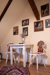 a dining room with a white table and two chairs at Casa Saseasca in Sighişoara
