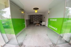 an office with a green wall and a lobby at Klepsidra rooms in Leptokarya