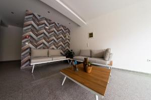 Sala de estar con 2 sofás y mesa en Klepsidra rooms, en Leptokarya