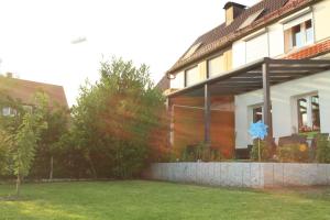 a house with a blue sign in the yard at Schöne Zeit in Friedrichshafen